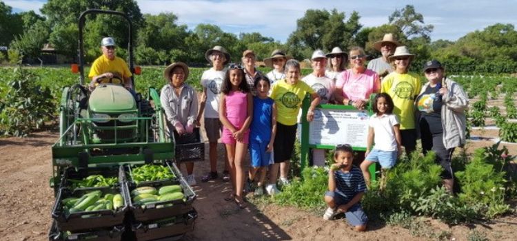 A group of master gardeners and children at an event